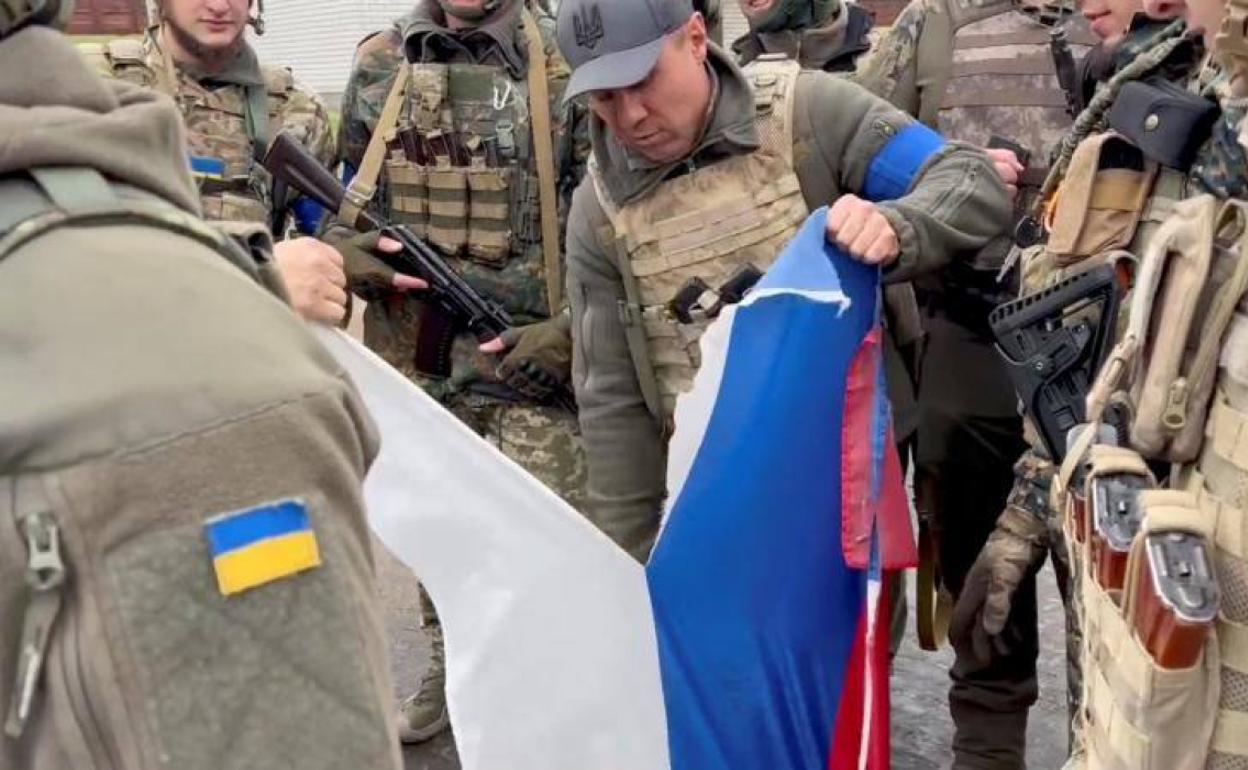 Unos soldados ucranianos rasgan la bandera rusa tras la toma de Járkov