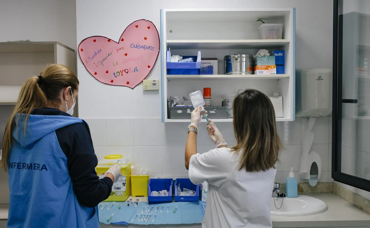 Imagen de archivo de dos enfermeras preparando dosis de vacuna contra la covid para administrarlas a domicilio a grandes dependientes. 