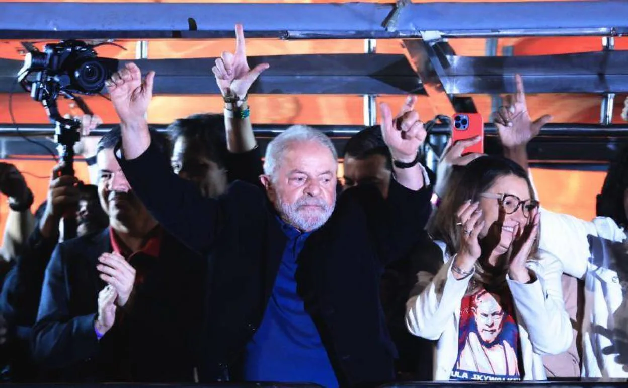 Lula celebra sus resultados ante simpatizantes en la Avenida Paulista de Sao Paulo acompañado de su esposa, Rosangela da Silva. Detrás, miembros de su equipo gesticulan haciendo una 'L' con las manos, símbolo de Lula.