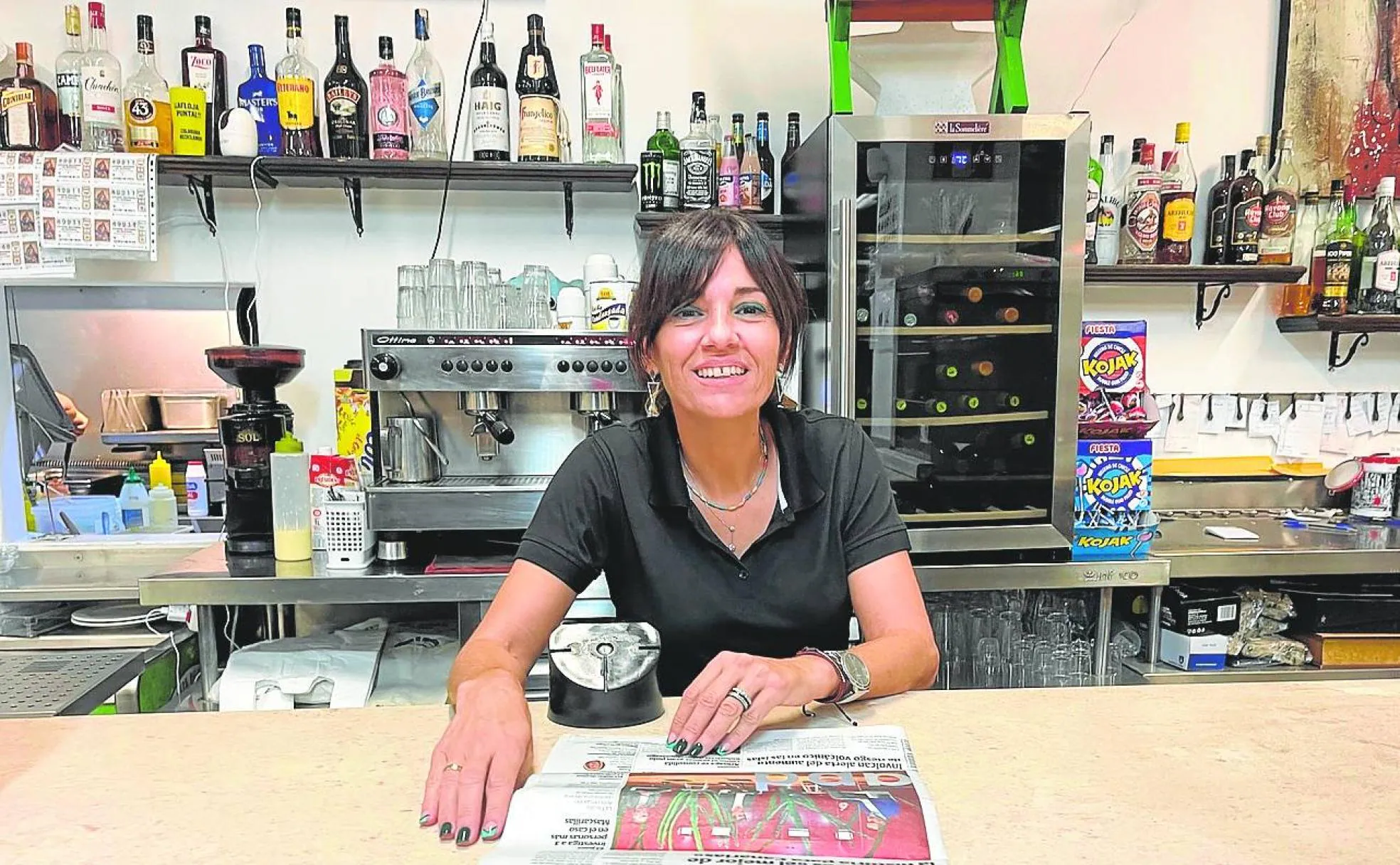Mariola Rodríguez, en su bar del Teleclub de Punta Mujeres, lee el periódico. 