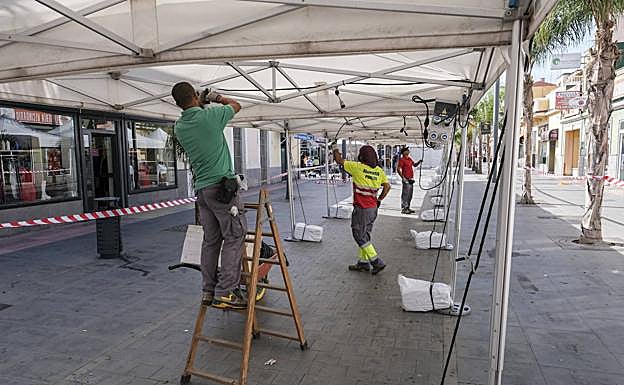 Operarios ultiman el montaje de las instalaciones de las casetas. 