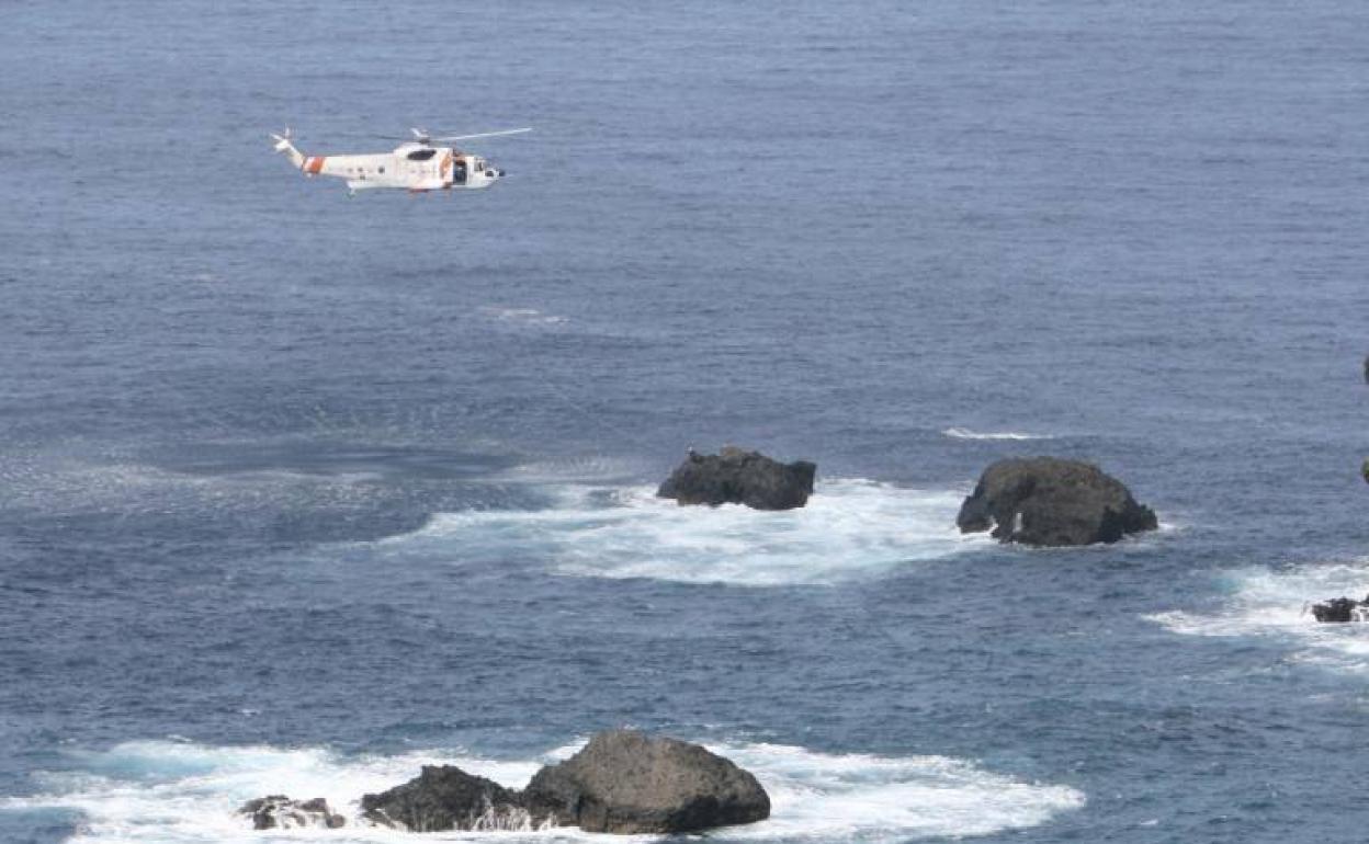 Imagen de archivo de un helicóptero volando sobre la costa canaria. 