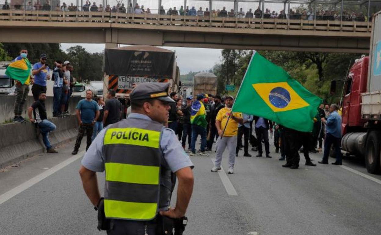 Un policía hace frente a la protesta de bolsonaristas que cortan una carretera de Sao Paolo. 