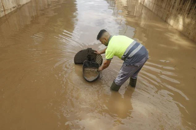 Numerosos pasos subterráneos de la Comunidad Valenciana quedaron inundados. En la imagen un operario desatasca uno en Xiribella.