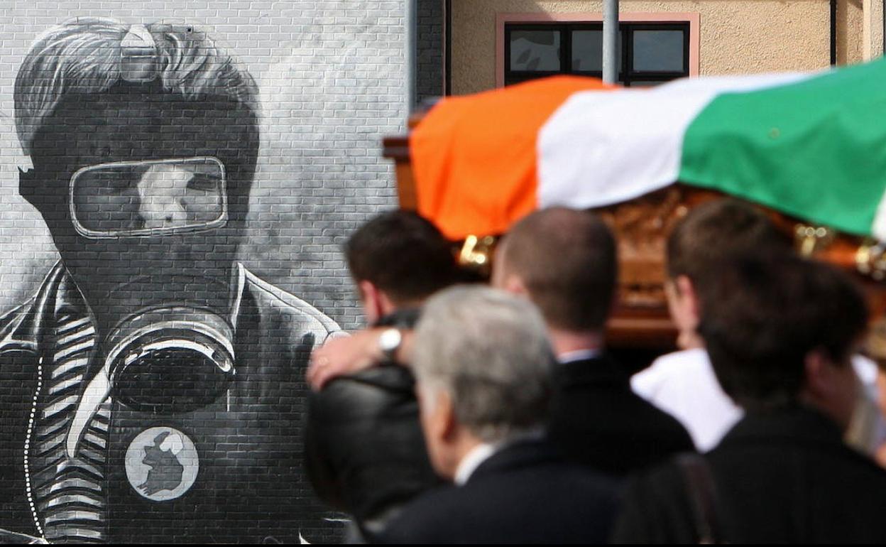 Un féretro cubierto por la bandera de Irlanda ante un mural alusivo a la Batalla del Bogside, en la localidad de Londonderry, en una imagen ajena a esta información.