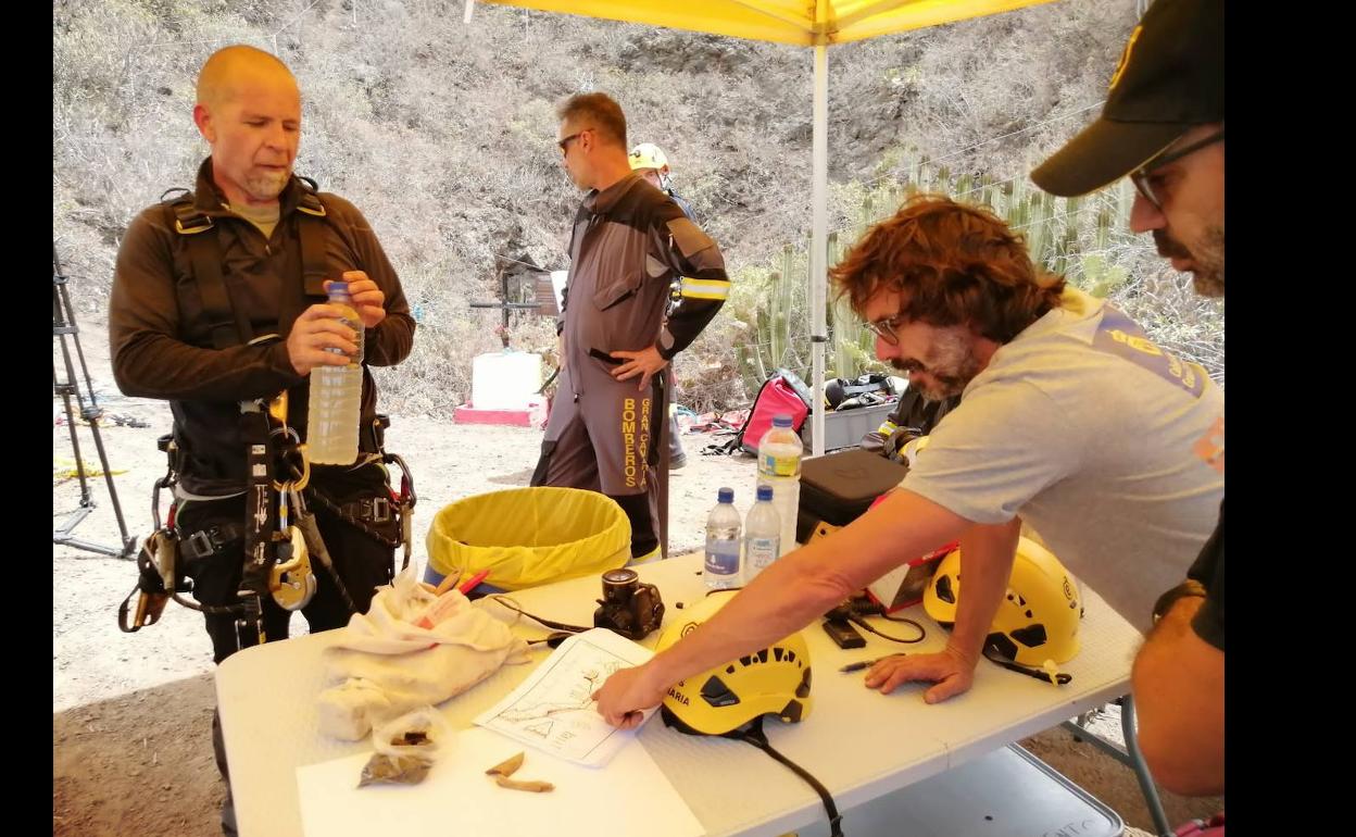 José Guillén muestra a Xavier Velasco un punto del interior de la Sima de Jinámar en un mapa. 