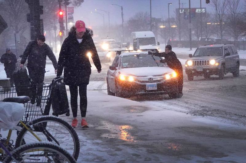 Peatones circulan por una acera cubierta de nieve mientras las temperaturas se desploman, el 22 de diciembre de 2022 en Chicago, Illinois.