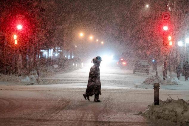 La gente cruza una calle en el Mile End, un barrio de Montreal, Quebec, Canadá, mientras cae la nieve el 22 de diciembre de 2022.