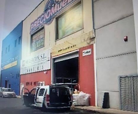 Ejemplo de fachada de nave de El Goro con varios colores y formatos publicitarios. 