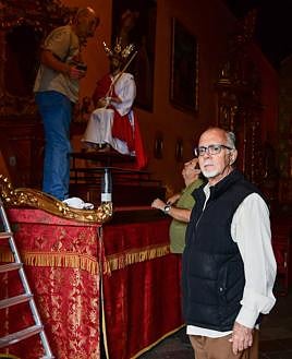 Imagen secundaria 2 - Arriba, el Cristo. Sobre estas líneas, Ramón con los arreglos florales y José Luis Rivero.