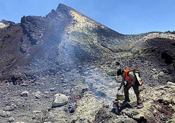 Un investigador toma muestras en una fractura en el cono del Tajogaite.
