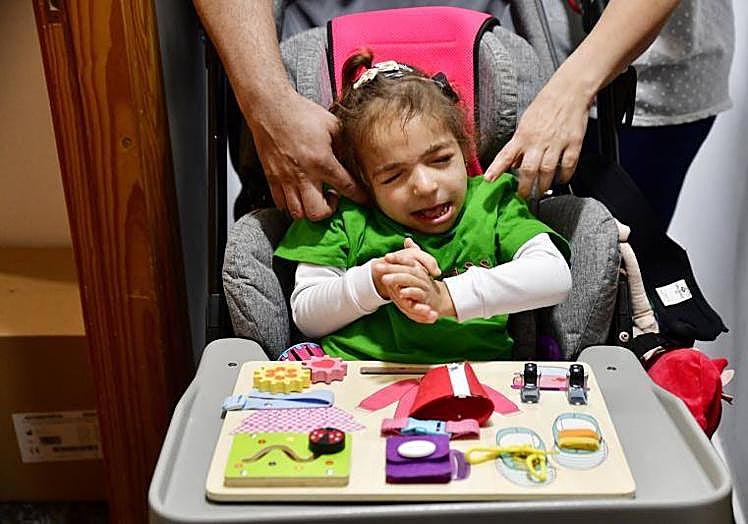 Marta, en su silla de ruedas, en medio del pasillo de su casa.