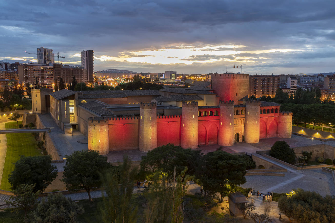 Fotografía del palacio del palacio de la Aljaferia iluminado con el rojo y el amarillo de la bandera de la comunidad con motivo de la celebración de el Día de Aragón en Zaragoza. 