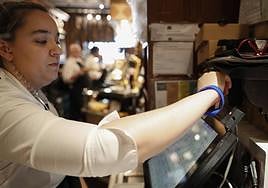 Una trabajadora ficha antes de comenzar su jornada laboral.