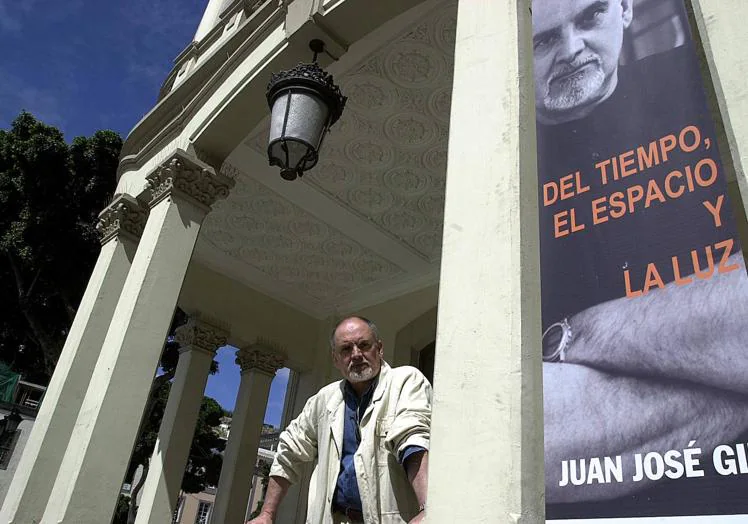 Juan José Gil, en 2004, junto al cartel anunciador de su exposición 'Del tiempo, el espacio y la luz', en la entrada del Gabinete Literario.