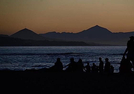 Atardecer en Las Canteras este lunes. En la foto superior, imagen de las luces.