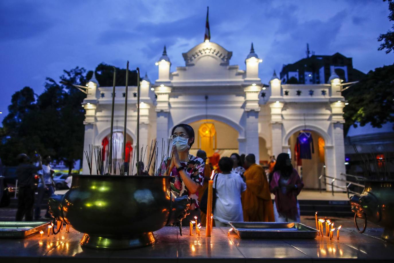 Una mujer (C) reza junto al templo, en vísperas de la celebración del Día de Wesak en Kuala Lumpur, Malasia. El día de Wesak conmemora el nacimiento, la iluminación y el fallecimiento de Gautama Buda, celebrado por los budistas de todo el mundo.
