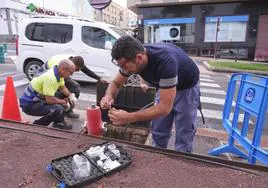 Los operarios del CAAF purgan la tubería y un trabajador externo analiza el agua en la calle León y Castillo, que forma parte de la misma red rota en la cercana Primero de Mayo.
