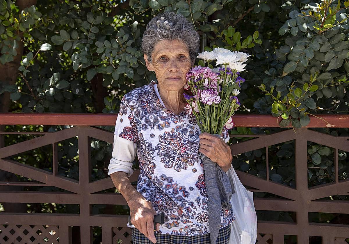 Eugenio Espino, vecina de Tejeda con unas flores, a su salida del cementerio.