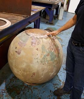 Imagen secundaria 2 - Juan Carlos García muestra una de las planchas nuevas que creó el taller, a modo de prueba. Debajo, muestrario de las piezas de bronce que sujetan los cristales del faro. Y al lado, esfera de cobre que va sobre la cúpula y que sirve de agarre a la veleta. 