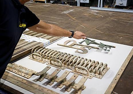 Imagen secundaria 1 - Juan Carlos García muestra una de las planchas nuevas que creó el taller, a modo de prueba. Debajo, muestrario de las piezas de bronce que sujetan los cristales del faro. Y al lado, esfera de cobre que va sobre la cúpula y que sirve de agarre a la veleta. 