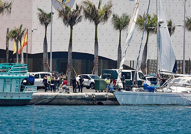 Los agentes junto al velero.