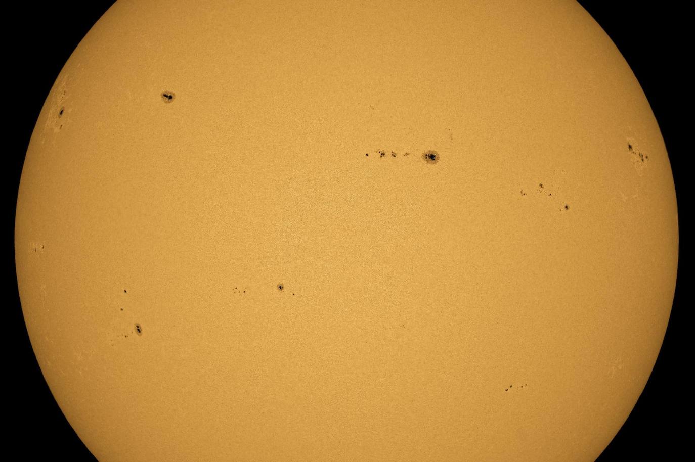 Se ven manchas solares en la superficie del Sol, capturadas desde Salgotarjan, Hungría. Las regiones más oscuras de la superficie solar son causadas por concentraciones de flujo magnético. Estos fenómenos de aumento de la actividad magnética solar pueden afectar el campo magnético terrestre y pueden perturbar el funcionamiento de los satélites y las redes eléctricas terrestres.