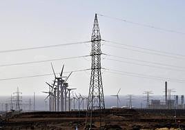 Torretas de alta tension y aeogeneradores en el entorno de la central térmica (derecha).