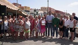 El grupo de gobierno posa con las mujeres del bingo playero tras la entrega de la placa.