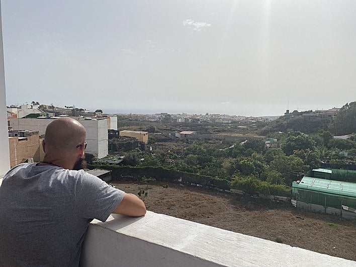 El vecino denunciante, en la azotea de su casa, mira a la finca donde están los gallos.