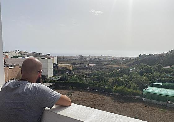 El vecino denunciante, en la azotea de su casa, mira a la finca donde están los gallos.