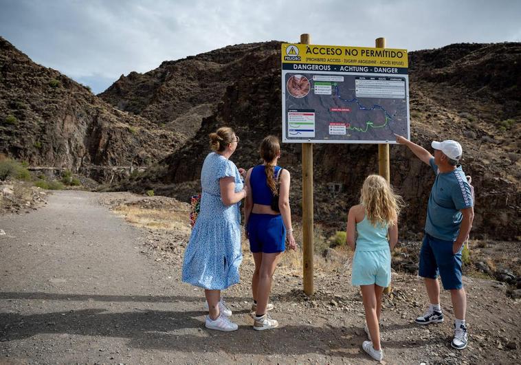 Familia de turistas advertidos por el cartel de que esta ruta no es la que buscan.