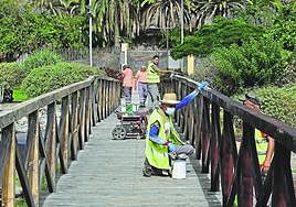 Operarios sincronizados para el mantenimiento del puente. Unos lijaban. Otros, detrás, barnizaban.