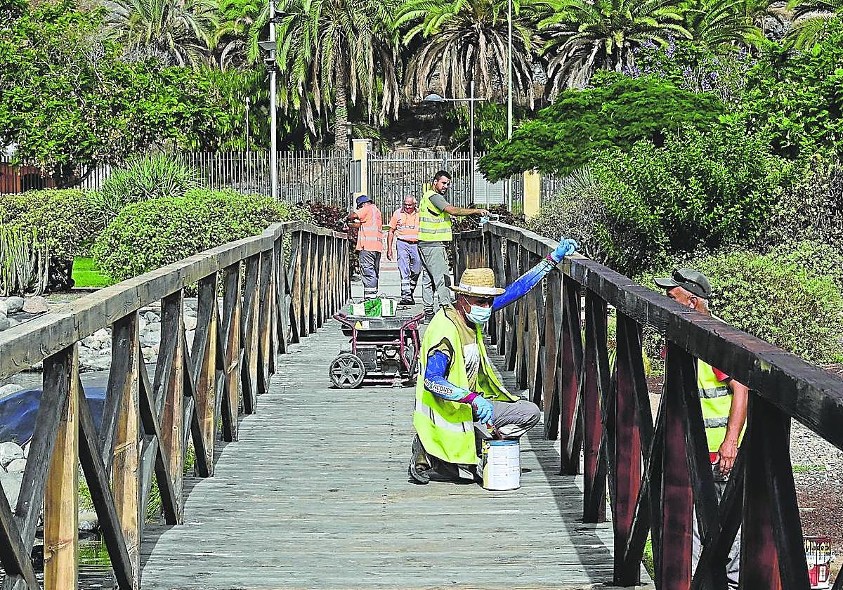 Operarios sincronizados para el mantenimiento del puente. Unos lijaban. Otros, detrás, barnizaban.