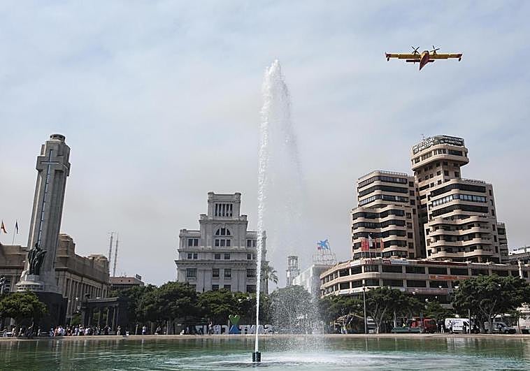 Un hidroavión destinado a las labores de extinción del incendio forestal que afecta a la isla de Tenerife sobrevuela la capital.