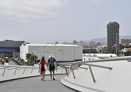 Una pareja usa la pasarela al regresar de la playa.