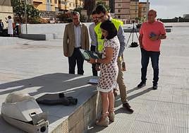 La alcaldesa contempla las nuevas luminarias junto a una vieja.