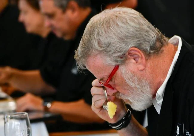 Uno de los miembros del jurado de la cata huele una papa sancochada.