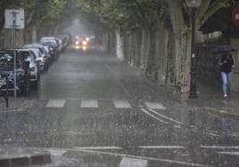 Una persona camina bajo la lluvia este sábado en Huesca.