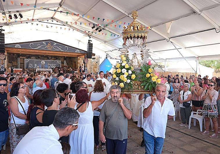 Juan José Camejo, con camisa blanca, lleva a hombros el trono de la patrona de Fuerteventura entre los aplausos de los fieles en Vega de Río Palmas.