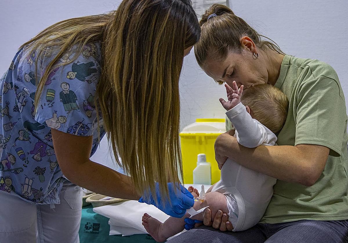 Imagen de archivo de una enfermera pinchando a un bebé.