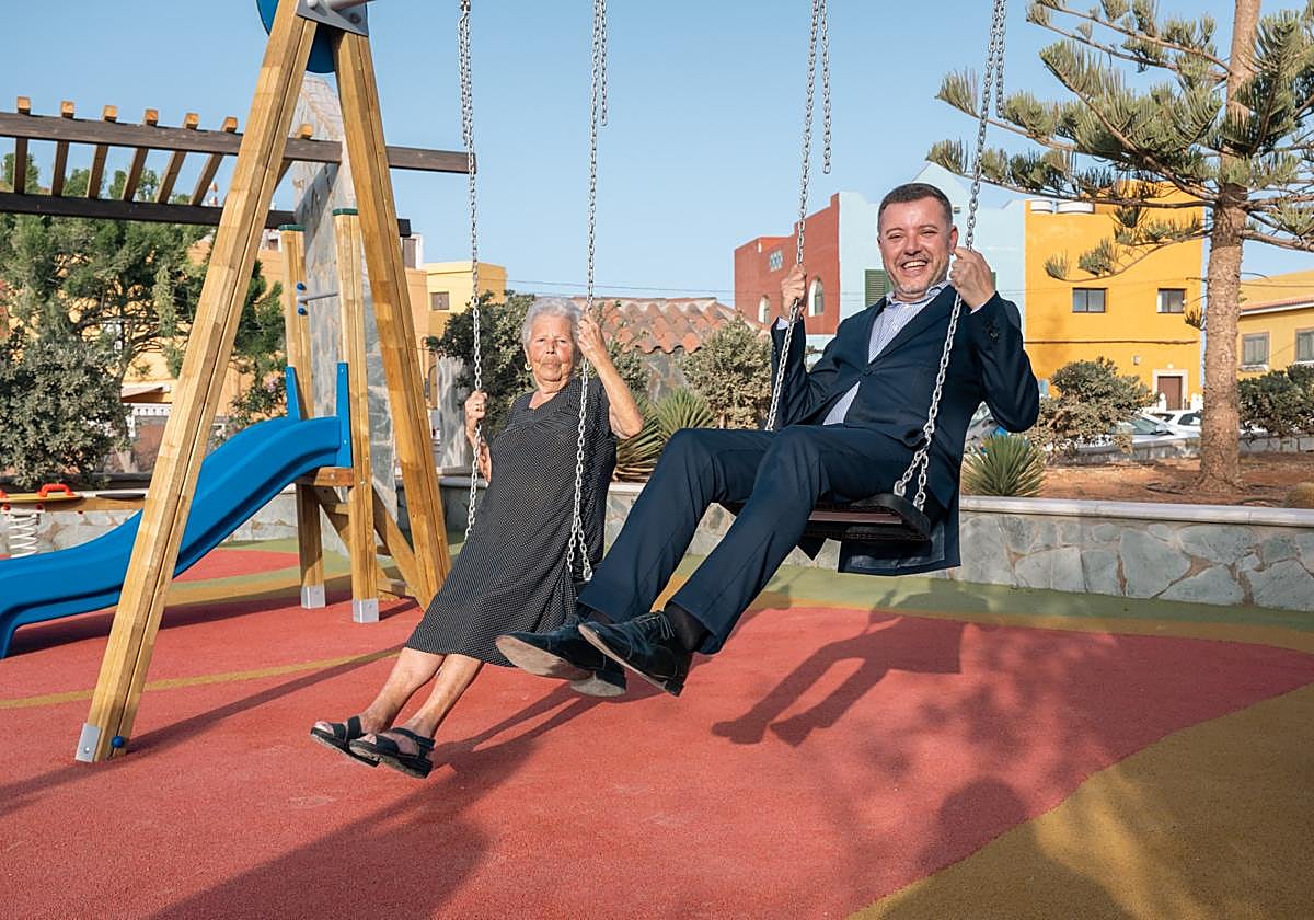 Teodoro Sosa, alcalde de Gáldar, en el columpio del parque infantil de La Punta junto a una vecina.