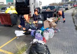 Trabajadores de FCC recogen la basura acumulada en una calle de Ciudad del Campo.