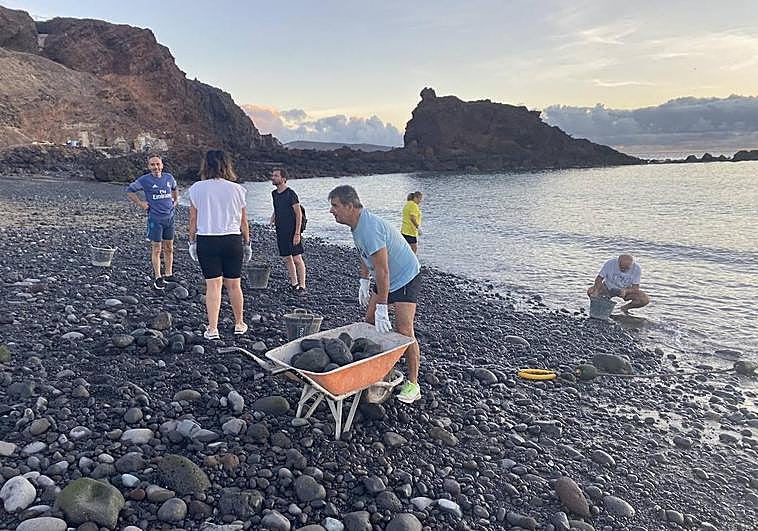 Parte del gobierno en plena faena en El Burrero. El alcalde, agachado, en el agua.
