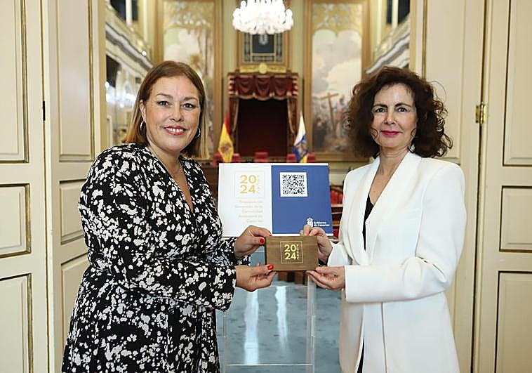 Astrid Pérez (izda.) recibe el proyecto de ley de Presupuestos Generales de manos de Matilde Asián.