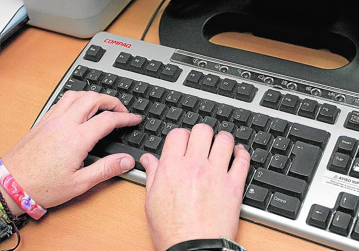 Imagen de archivo de una persona tecleando en un ordenador.