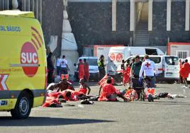 Varios migrantes son atendidos por los servicios de emergencias, en el muelle de La Restinga,