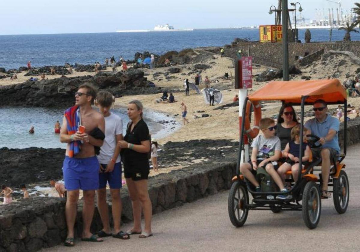 Un grupo de turistas pasean por el núcleo turístico de Costa Teguise, en Lanzarote.