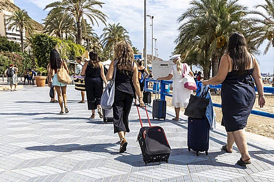 Turistas tirando de sus maletas.