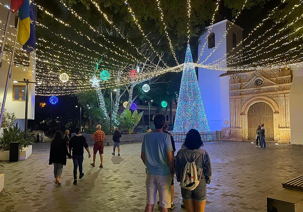 Visitantes contemplan las luces navideñas de la plaza de la iglesia de Pájara.